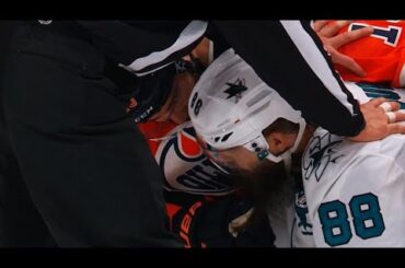 Patrick Maroon tugs on the beard of Brent Burns